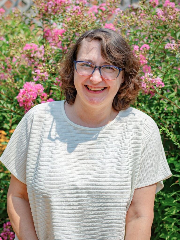 Staff member pictured in front of flower bushes on the Horizon Academy campus.
