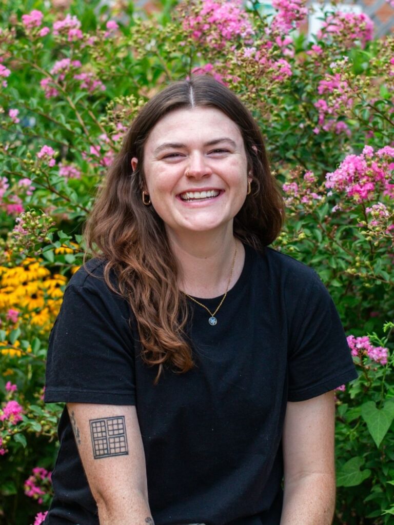 Staff member pictured in front of flower bushes on the Horizon Academy campus.