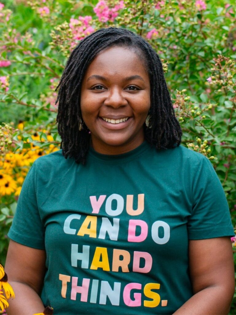 Staff member pictured in front of flower bushes on the Horizon Academy campus.