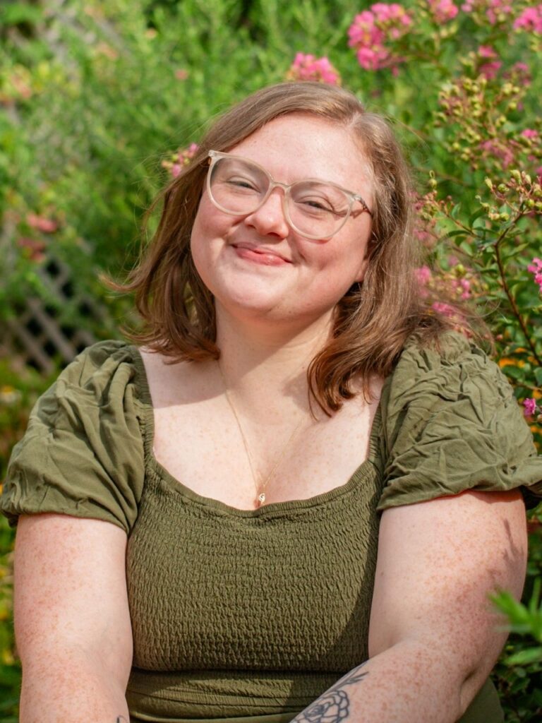 Staff member pictured in front of flower bushes on the Horizon Academy campus.