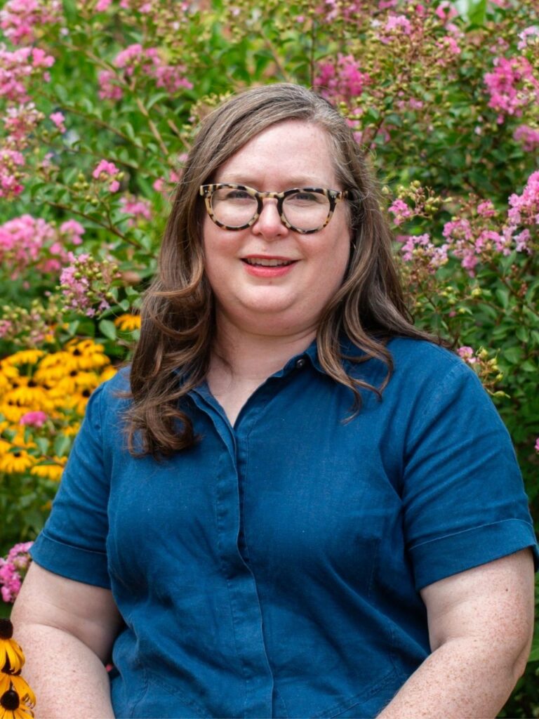 Staff member pictured in front of flower bushes on the Horizon Academy campus.