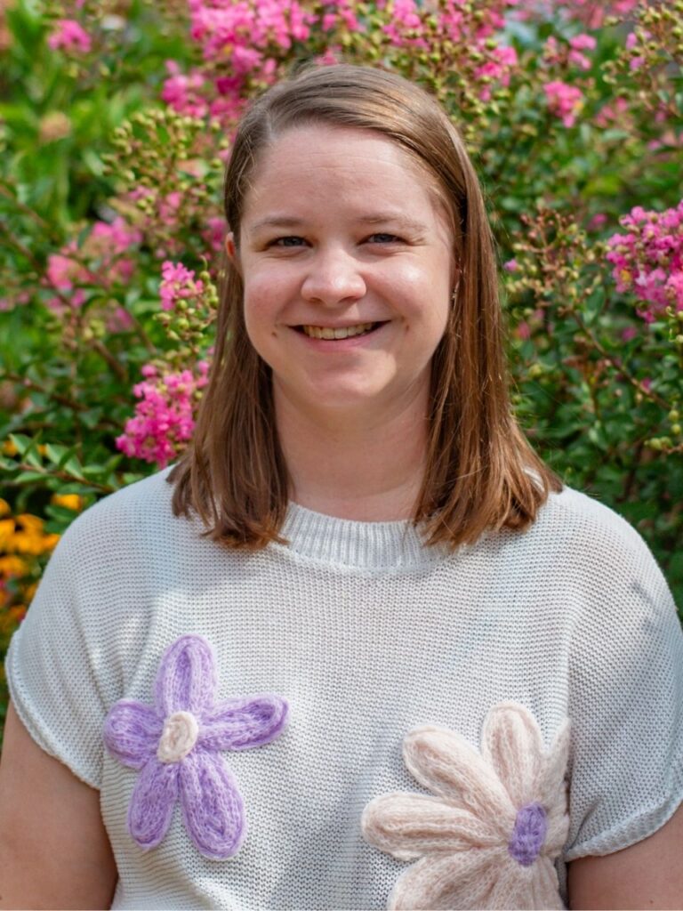 Staff member pictured in front of flower bushes on the Horizon Academy campus.