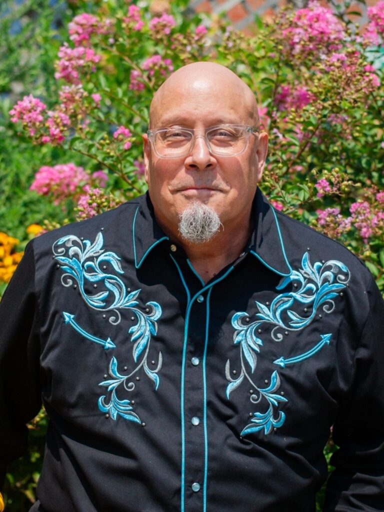 Staff member pictured in front of flower bushes on the Horizon Academy campus.