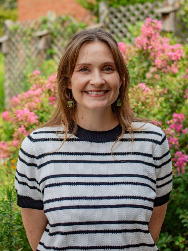 Staff member pictured in front of flower bushes on the Horizon Academy campus.