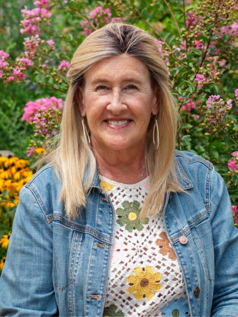 Staff member pictured in front of flower bushes on the Horizon Academy campus.