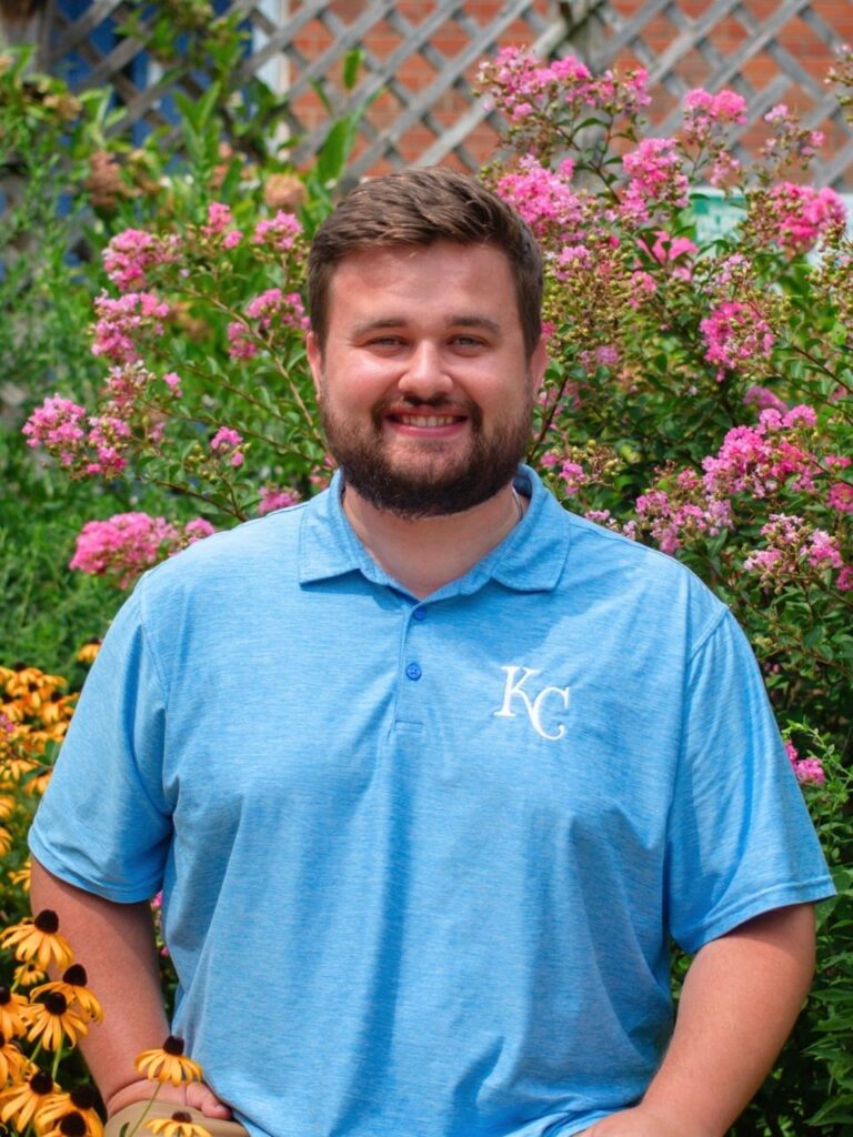 Staff member pictured in front of flower bushes on the Horizon Academy campus.