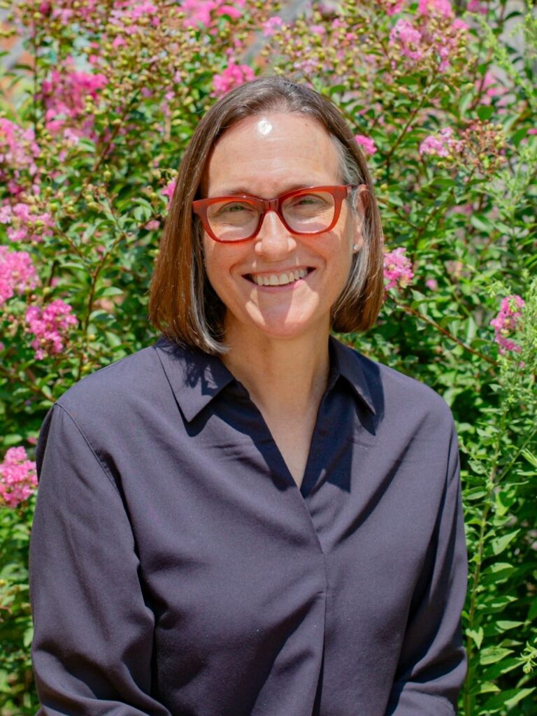 Staff member pictured in front of flower bushes on the Horizon Academy campus.