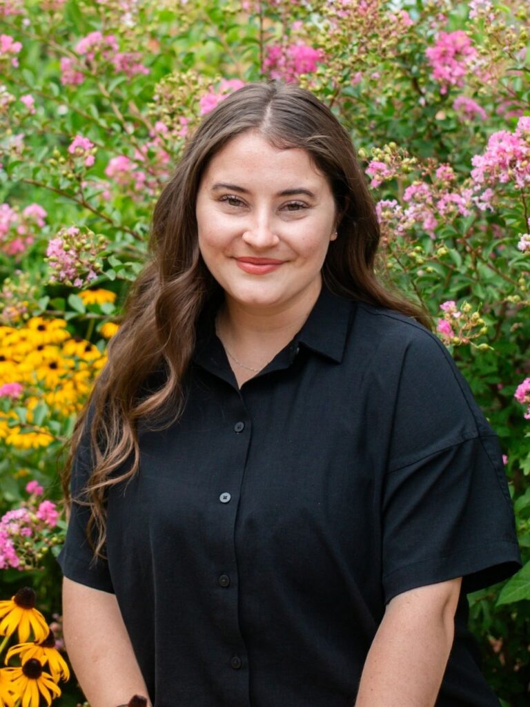 Staff member pictured in front of flower bushes on the Horizon Academy campus.