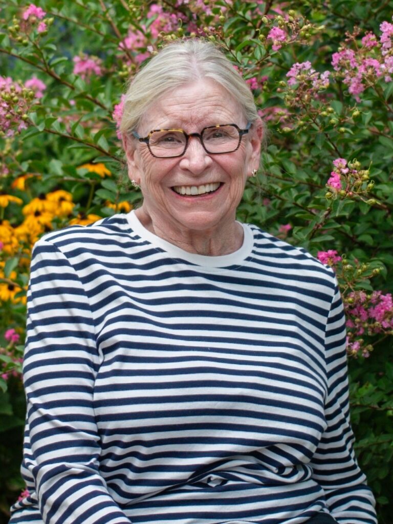 Staff member pictured in front of flower bushes on the Horizon Academy campus.