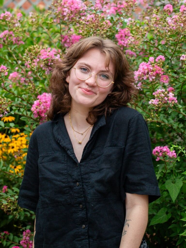 Staff member pictured in front of flower bushes on the Horizon Academy campus.