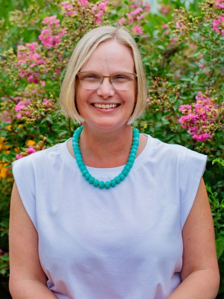 Staff member pictured in front of flower bushes on the Horizon Academy campus.