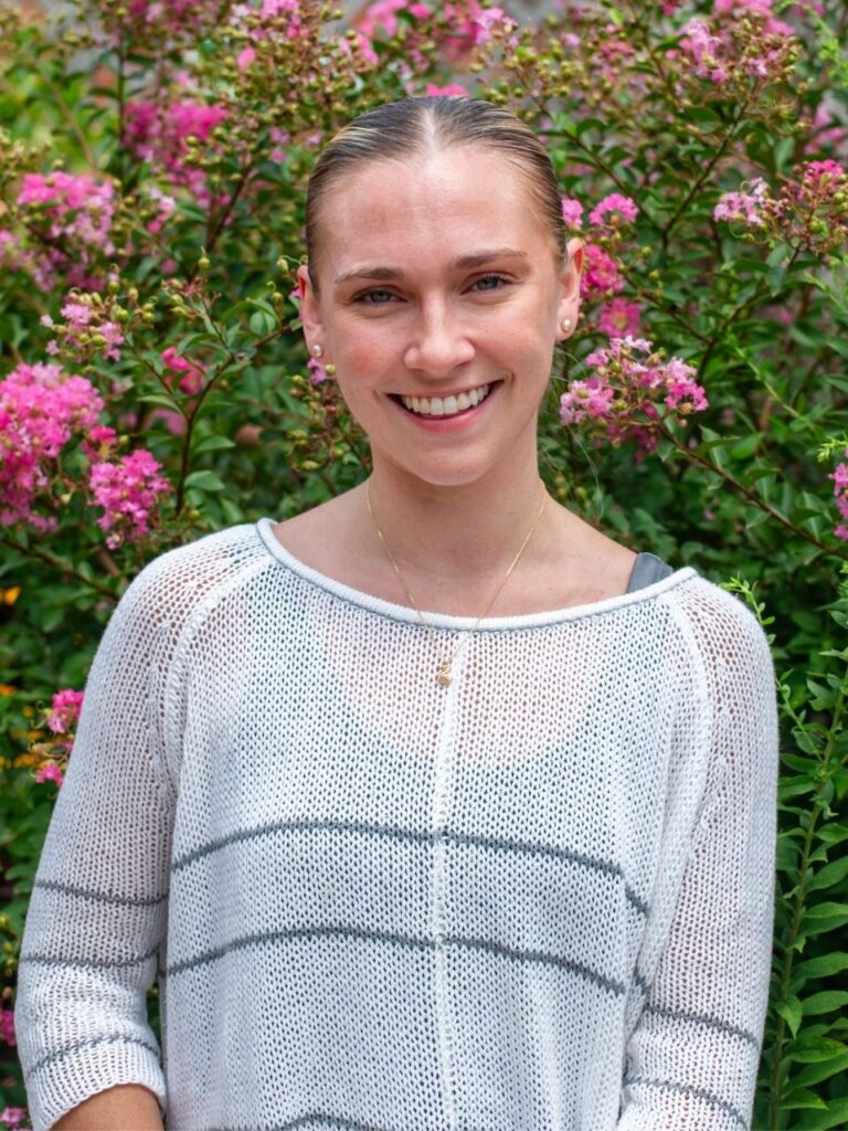 Staff member pictured in front of flower bushes on the Horizon Academy campus.