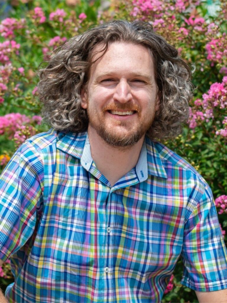 Staff member pictured in front of flower bushes on the Horizon Academy campus.